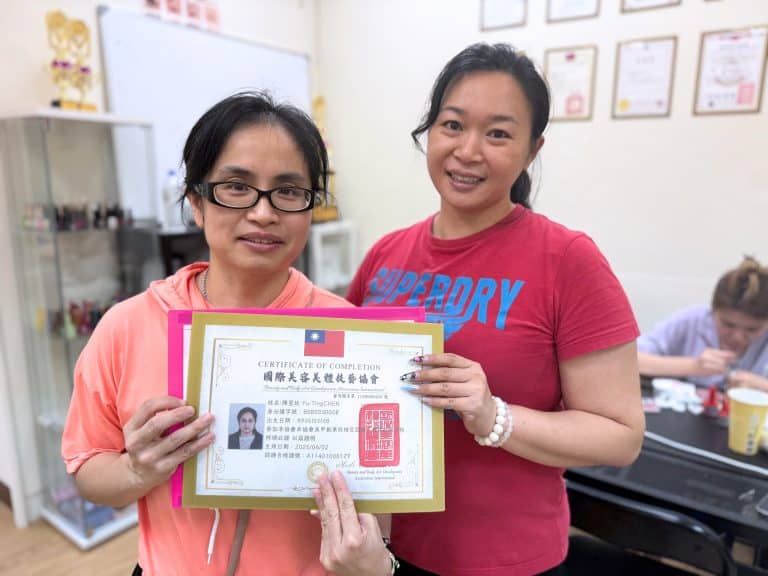 美甲學員結業合影，手持幸妍國際美學苑結業證書與公會檢定證書，見證從零基礎到專業美甲師的學習成果。